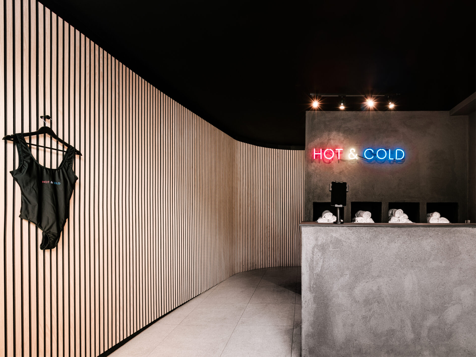 FRONT DESK VIEW | Front-of-house perspective showing the curved wall guiding visitors into the waiting area.